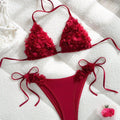 Red bikini set with floral details on a white surface