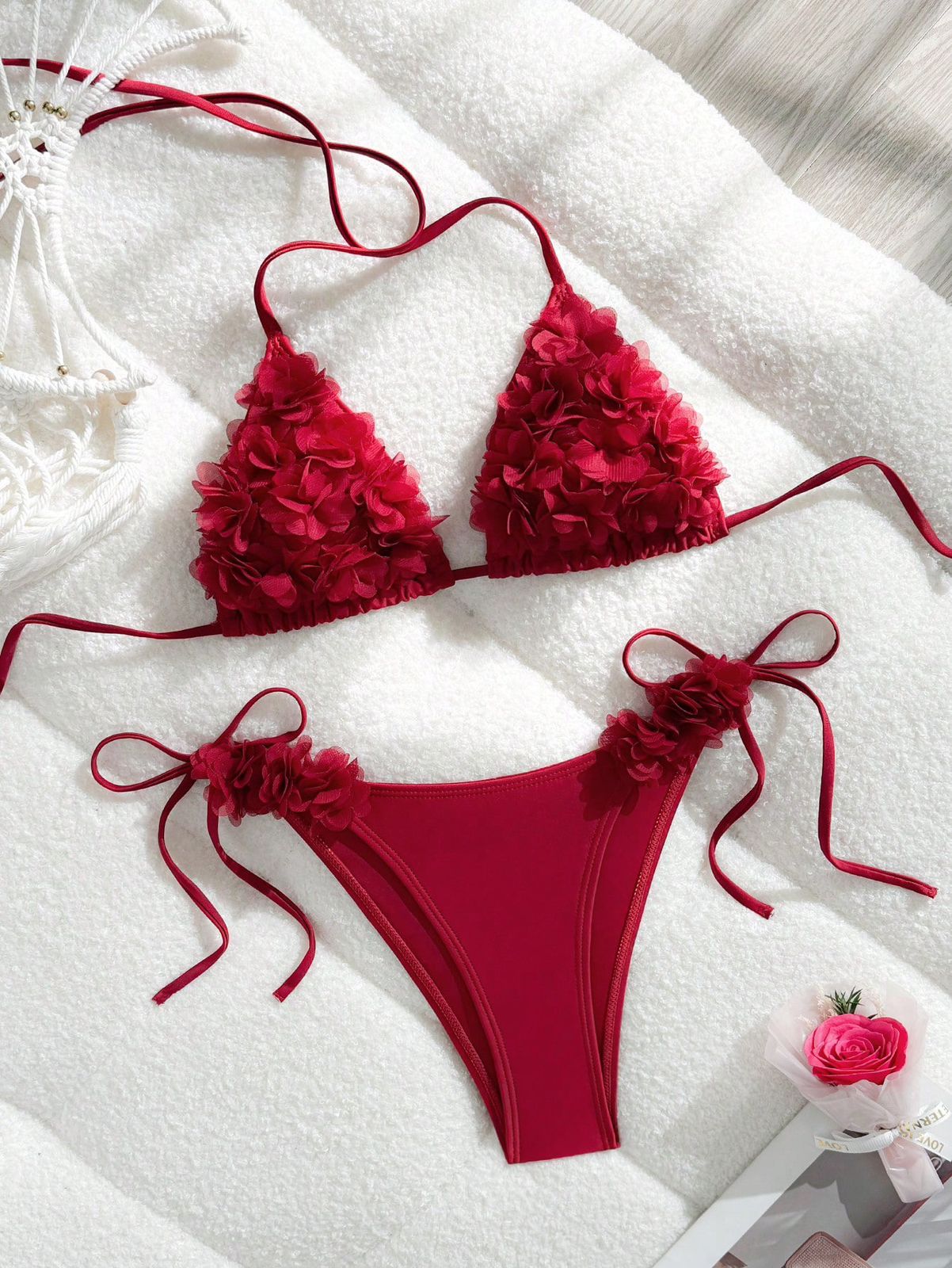 Red bikini set with floral details on a white surface