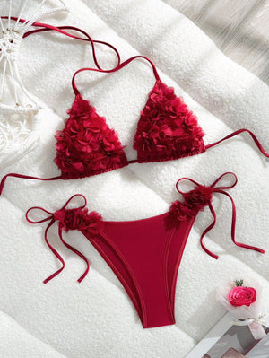 Red bikini set with floral details on a white surface