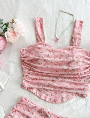 Pink floral dress on a light background with flowers and jewelry.